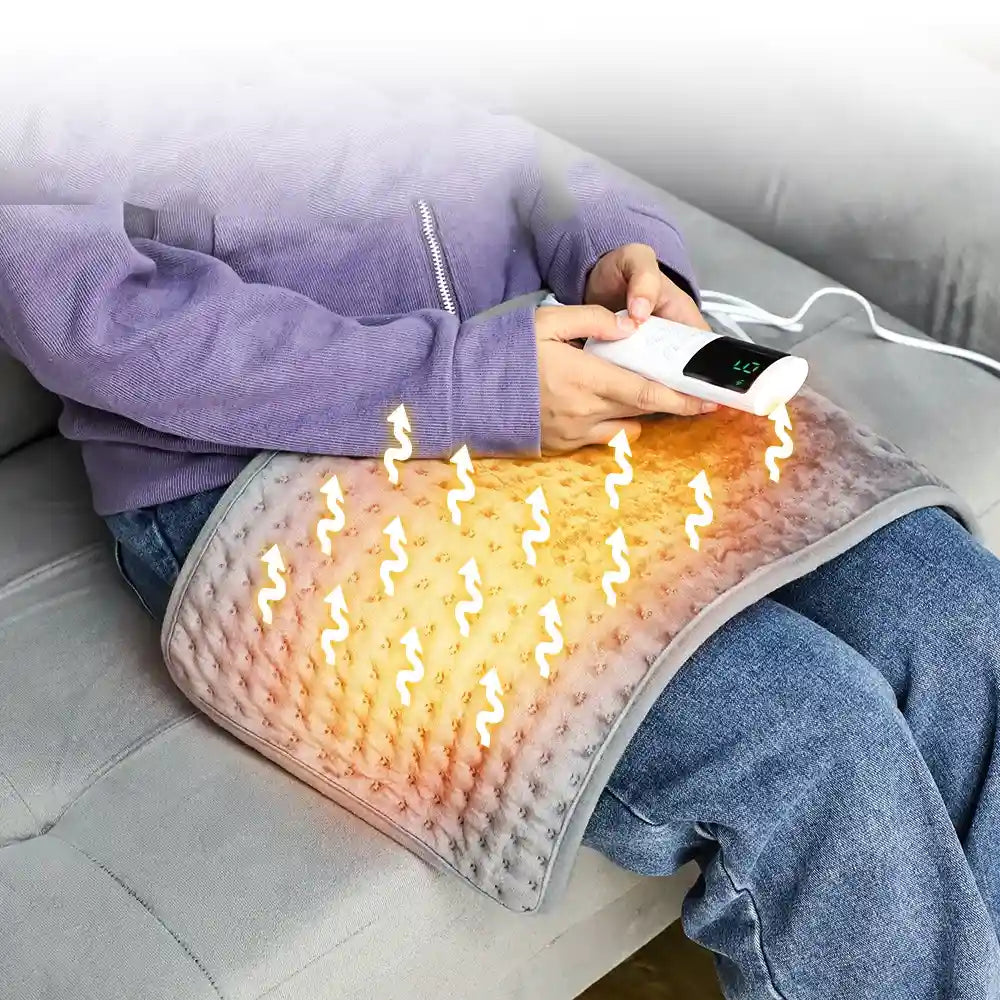 Personne appliquant la petite couverture chauffante sur ses genoux pour une diffusion de chaleur apaisante.