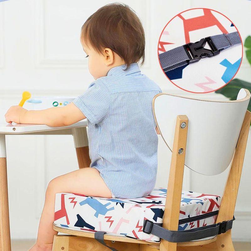 Enfant à table sur un coussin rehausseur enfant multicolore