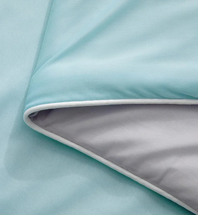 Détail du bord de la couverture rafraîchissante CryoComfort™, montrant les deux faces pour un confort thermique modulable.

