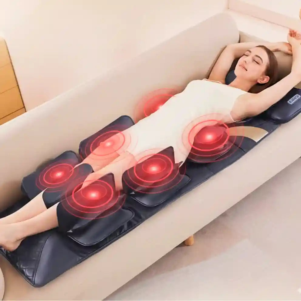 Femme se relaxant sur le tapis de massage AeroForm™ installé sur un canapé, montrant l'action des airbags et de la chaleur.
