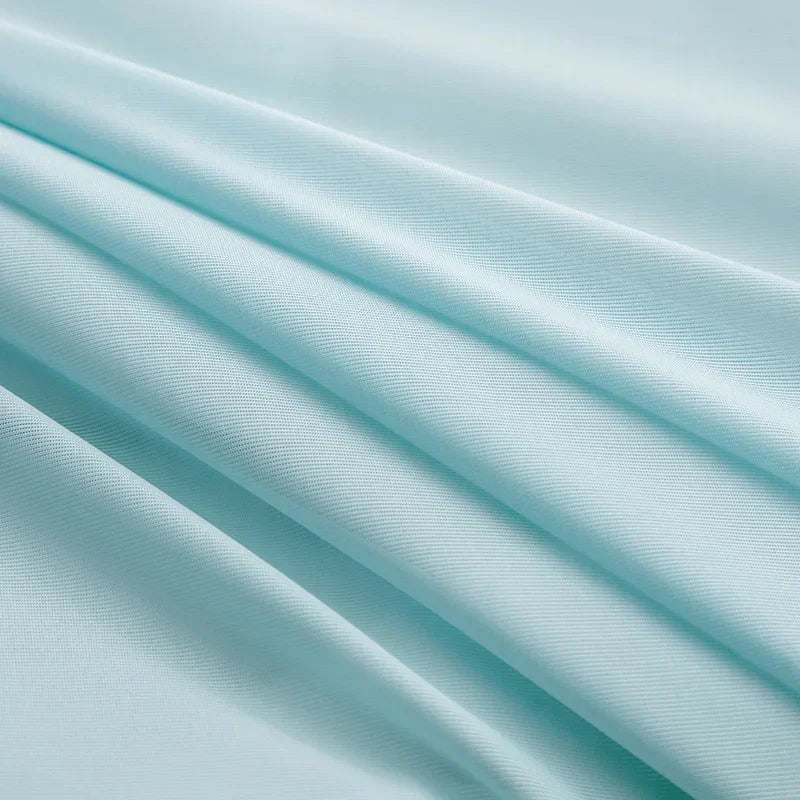 Gros plan sur la texture du tissu "Ice Silk" de la couverture rafraîchissante CryoComfort™, montrant sa douceur et sa capacité thermorégulatrice.